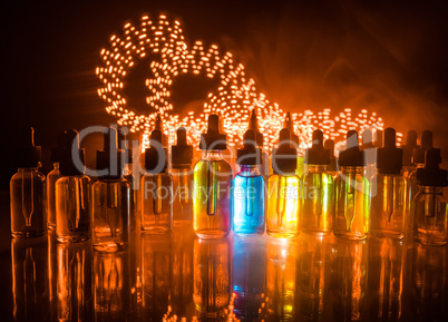 Vape concept. Smoke clouds and vape liquid bottles on dark background. Light effects. Useful as background or electronic cigarette advertisement.