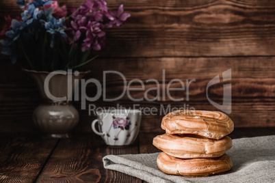 Eclairs stack on table with cup of coffee
