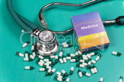 Health care medical and sickness concept. Pills and medical equipment background with a drug box fake write "Medicine".