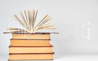 stack of books and an open book with yellow pages