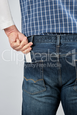 man puts an empty white paper business card in his back jeans po