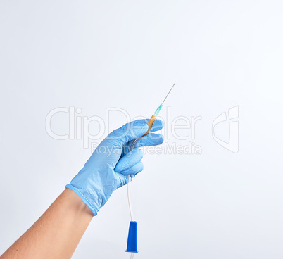hand in blue sterile glove holds plastic dropper system