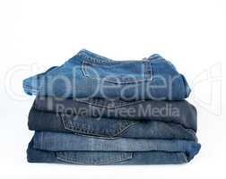 stack of folded blue jeans on a white background