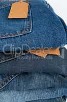 stack of folded blue jeans on a white background