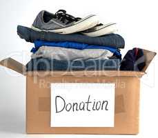 folded clothes and shoes in a brown paper box