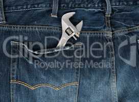 metal adjustable wrench in blue jeans back pocket