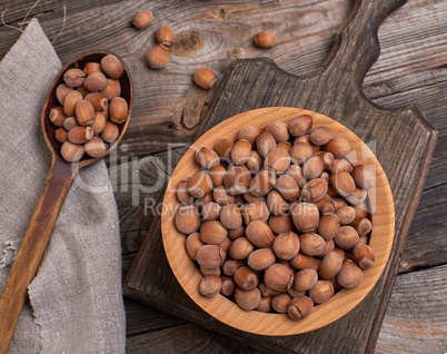 hazelnut nuts in a brown wooden bowl