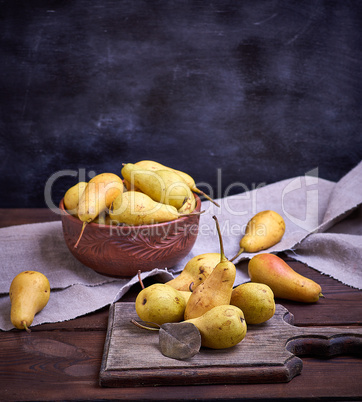 ripe yellow  pears in a brown clay bowl