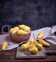 ripe yellow  pears in a brown clay bowl