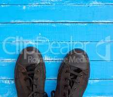 men's old sneakers on a blue wooden surface