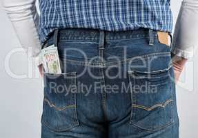 bundle of paper money in the back pocket of blue jeans