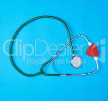 green medical stethoscope and red wooden heart
