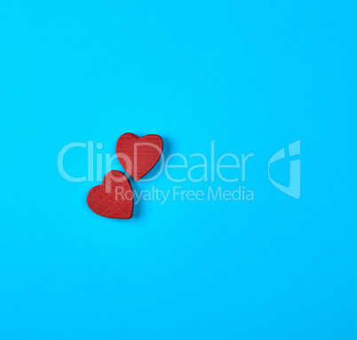 two red wooden hearts on a blue background