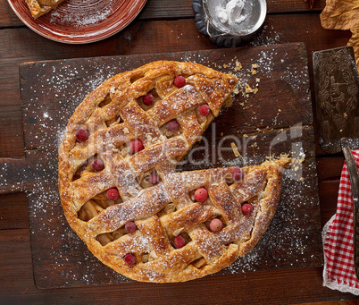 round apple pie on a rectangular old brown cutting board sprinkl
