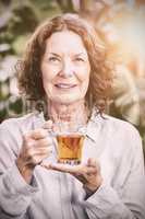 Smiling mature woman drinking herbal tea