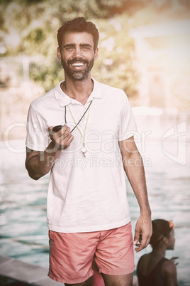 Male instructor standing at poolside