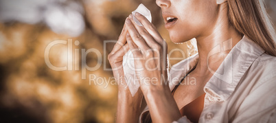 Beautiful woman using tissue while sneezing