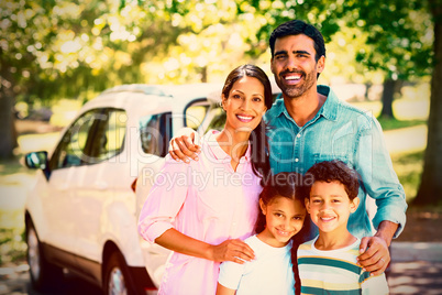 Happy family on a picnic standing next to their car