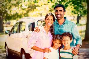 Happy family on a picnic standing next to their car