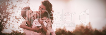 Young man piggybacking woman at farm during sunny day