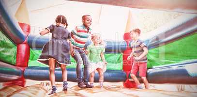 Friends playing on bouncy castle at playground