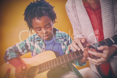 Boy learning to play guitar