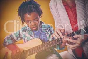 Boy learning to play guitar