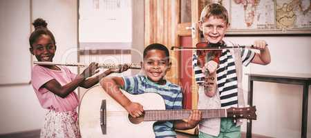 Portrait of children playing musical instruments in classroom
