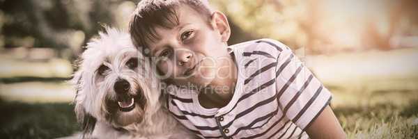 Portrait of boy with dog in park