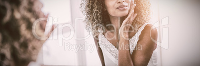 Woman checking her skin in bathroom