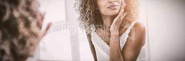 Woman checking her skin in bathroom