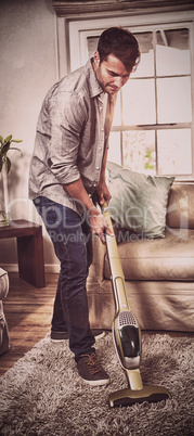 Man cleaning a carpet with a vacuum cleaner