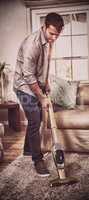 Man cleaning a carpet with a vacuum cleaner