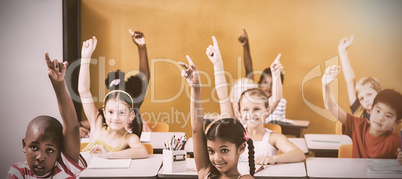 Students raising hands in classroom