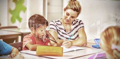 Teacher helping kids with their homework in classroom