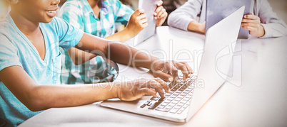 Kids using laptop and digital tablet in library