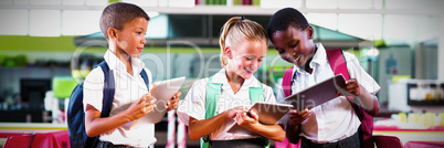 School kids using digital tablet in school cafeteria