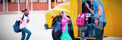 Teacher giving high five to kids while entering in bus