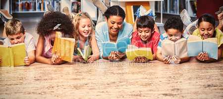 Teacher with students reading books while lying down