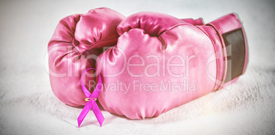 Close-up of pink Breast Cancer Awareness ribbon with boxing gloves