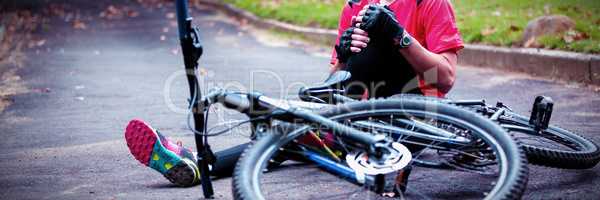 Male cyclist getting injured while falling from mountain bike