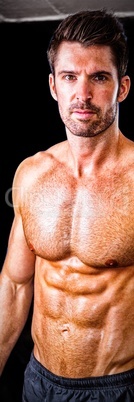 Portrait of shirtless male athlete in gym