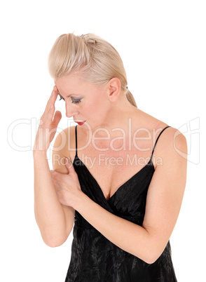 Woman looking down hand on head thinking