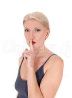 Blond woman in close-up with finger over mouth