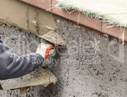 Tile Worker Applying Cement with Trowel at Pool Construction Site