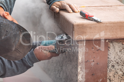 Construction Worker Using Grinder At Construction Site