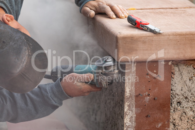 Construction Worker Using Grinder At Construction Site