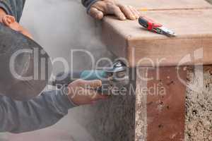 Construction Worker Using Grinder At Construction Site