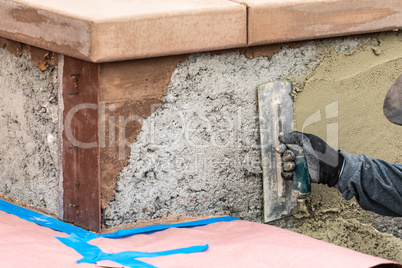 Tile Worker Applying Cement with Trowel at Pool Construction Site