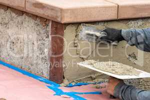 Tile Worker Applying Cement with Trowel at Pool Construction Site